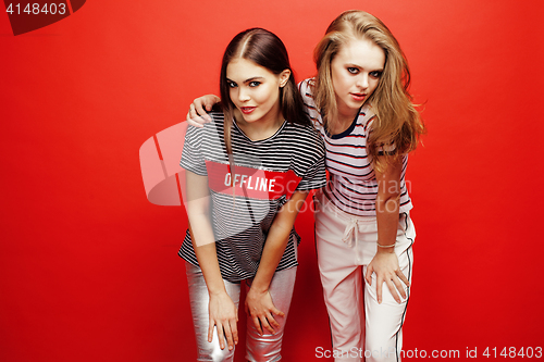 Image of two best friends teenage girls together having fun, posing emotional on red background, besties happy smiling, lifestyle people concept