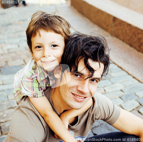 Image of little son with father in city hagging and smiling, casual look outside playing, happy real family, lifestyle people concept