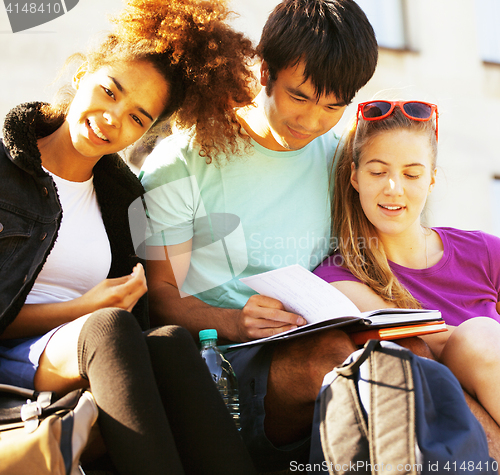 Image of cute group of teenages at the building of university with books 