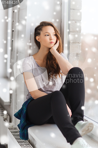 Image of sad pretty teenage girl looking through window
