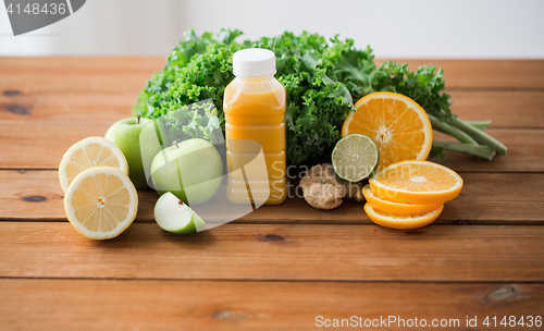 Image of bottle with orange juice, fruits and vegetables