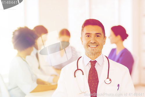 Image of happy doctor over group of medics at hospital