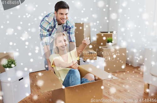 Image of happy couple having fun with boxes at new home