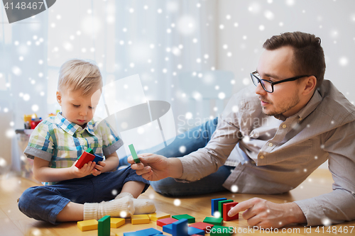 Image of father and son playing with toy blocks at home