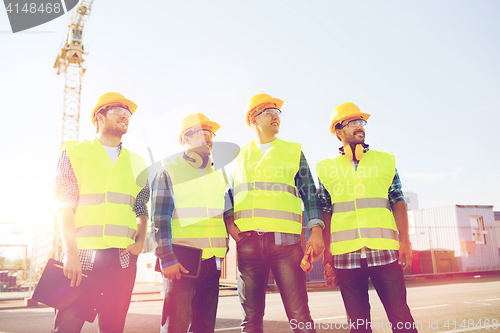 Image of group of smiling builders with tablet pc outdoors