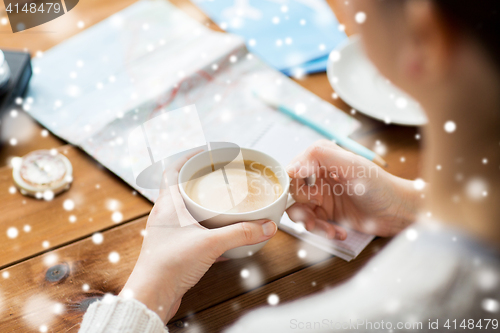 Image of close up of hands with coffee cup and travel stuff