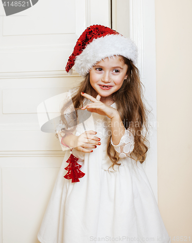 Image of little cute girl in santas red hat waiting for Christmas gifts. holiday lifestyle people concept