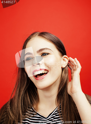 Image of young pretty emitonal posing teenage girl on bright red background, happy smiling lifestyle people concept