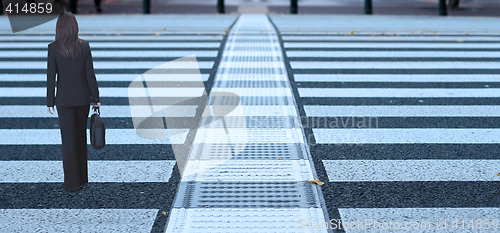 Image of Businesswoman crossing the street