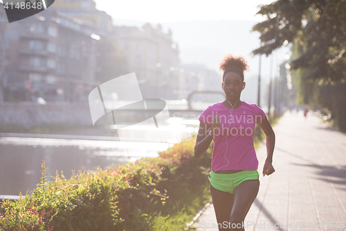 Image of african american woman jogging in the city