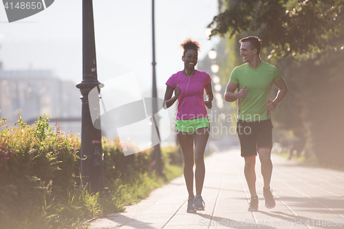 Image of young multiethnic couple jogging in the city