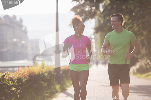 Image of young multiethnic couple jogging in the city