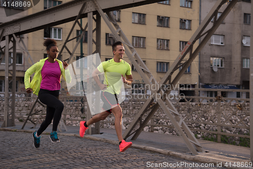 Image of young multiethnic couple jogging in the city