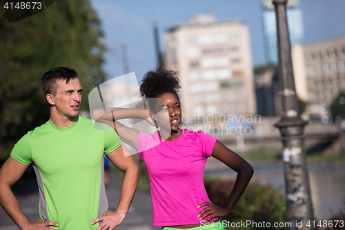 Image of portrait of young multietnic jogging couple ready to run