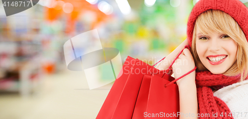 Image of woman in hat and scarf shopping at supermarket