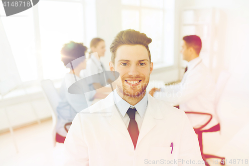 Image of happy doctor over group of medics at hospital