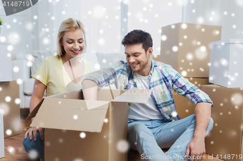 Image of smiling couple with big boxes moving to new home