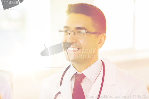 Image of smiling male doctor in white coat and eyeglasses