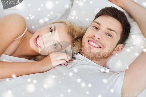 Image of happy couple lying in bed at home