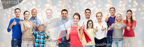 Image of happy people with shopping bags showing thumbs up