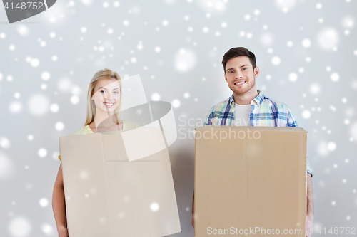 Image of smiling couple with big boxes moving to new home