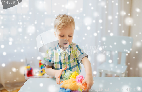 Image of happy little baby boy with ball clay at home