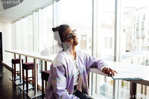 Image of young cute hipster girl student sitting in cafe with notebook re