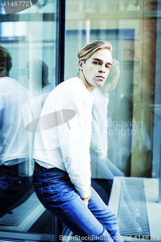 Image of young modern hipster guy at new building university blond fashio