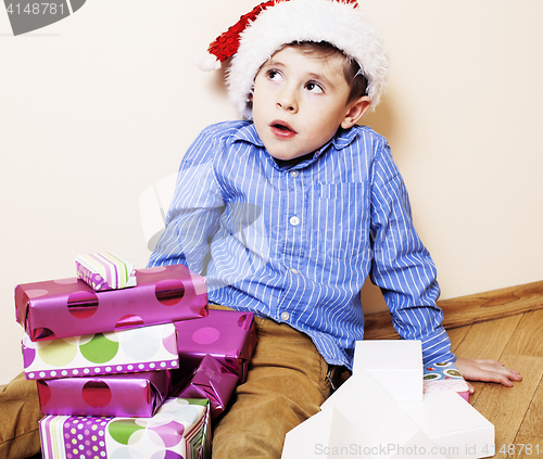 Image of little cute boy with Christmas gifts at home. close up emotional