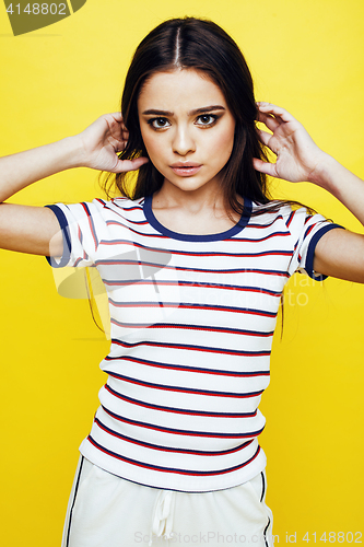 Image of young pretty teenage woman emotional posing on yellow background, fashion lifestyle people concept