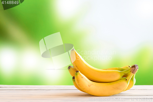 Image of Yellow bananas on a wooden table