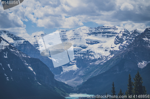 Image of Mountain peaks with snow and cloudy sky