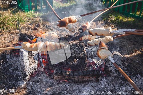 Image of Bread on sticks over an outdoor campfire