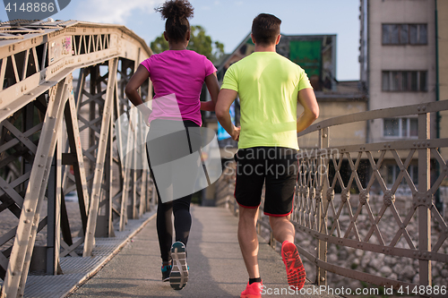 Image of multiethnic couple jogging in the city