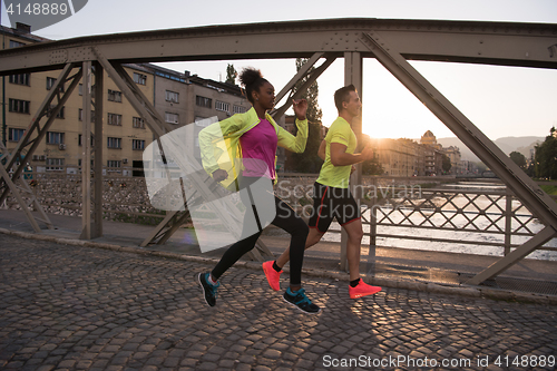 Image of young multiethnic couple jogging in the city