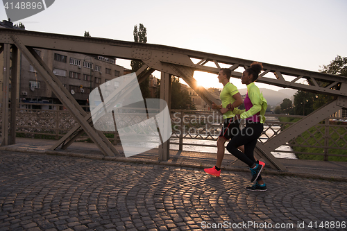 Image of young multiethnic couple jogging in the city