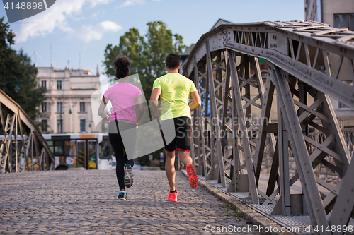 Image of multiethnic couple jogging in the city
