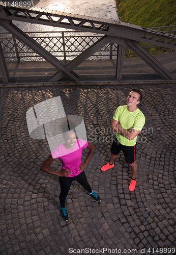 Image of portrait of a young multiethnic couple jogging in the city