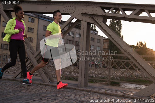 Image of young multiethnic couple jogging in the city