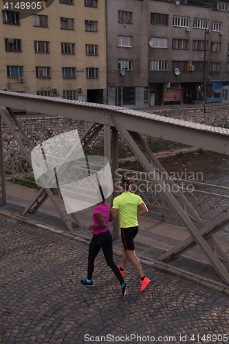 Image of young multiethnic couple jogging in the city