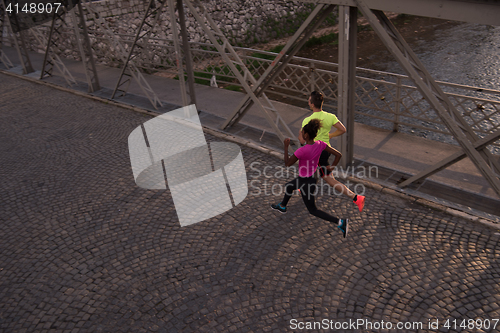 Image of young multiethnic couple jogging in the city