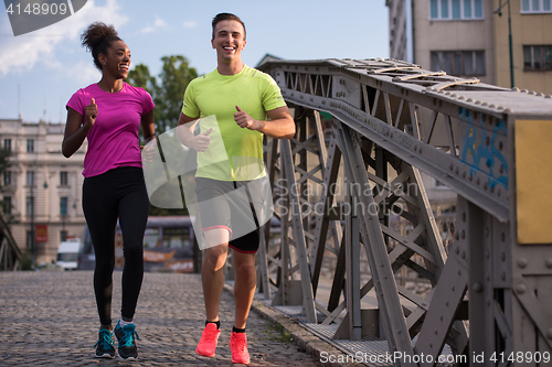 Image of multiethnic couple jogging in the city