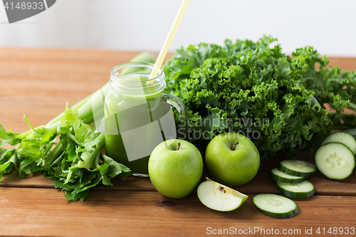 Image of close up of jug with green juice and vegetables