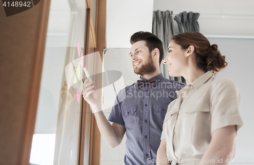 Image of creative team with stickers on glass at office