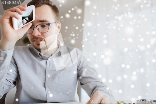 Image of businessman with smarphone at home office