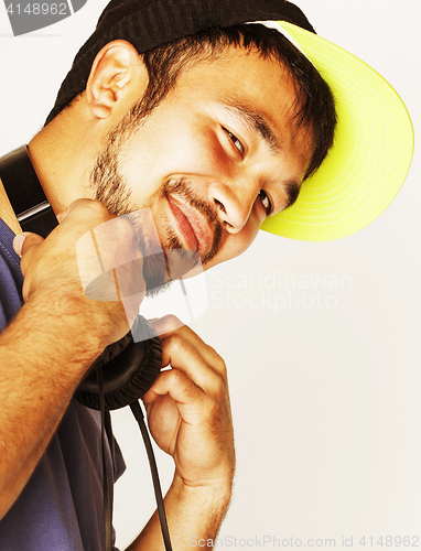 Image of young asian man in hat and headphones listening music on white b