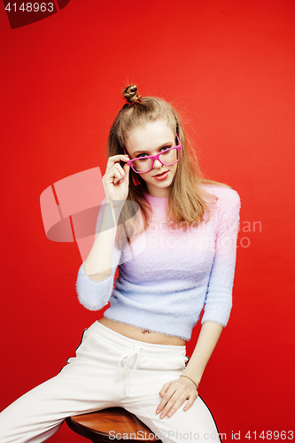 Image of young pretty emitonal posing teenage girl on bright red background, happy smiling lifestyle people concept