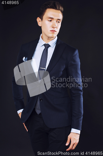 Image of young pretty business man standing on black background, modern h