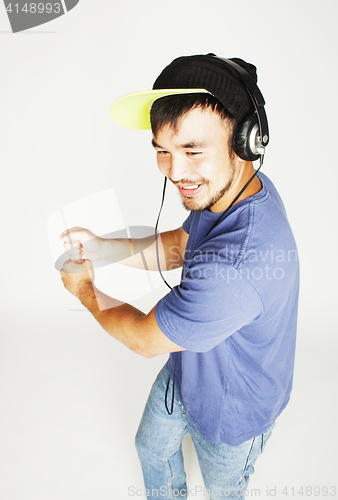 Image of young asian man in hat and headphones listening music on white b