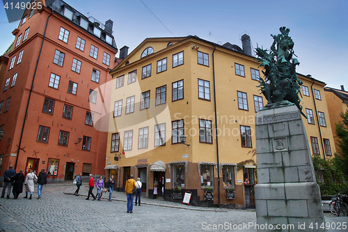 Image of STOCKHOLM, SWEDEN - AUGUST 19, 2016: Tourists walk and Statue of